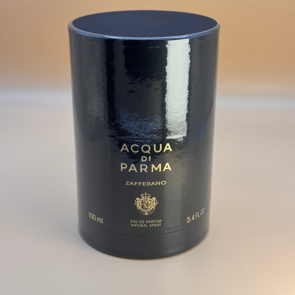 Black cylindrical container of Acqua di Parma Zafferano perfume on a beige background