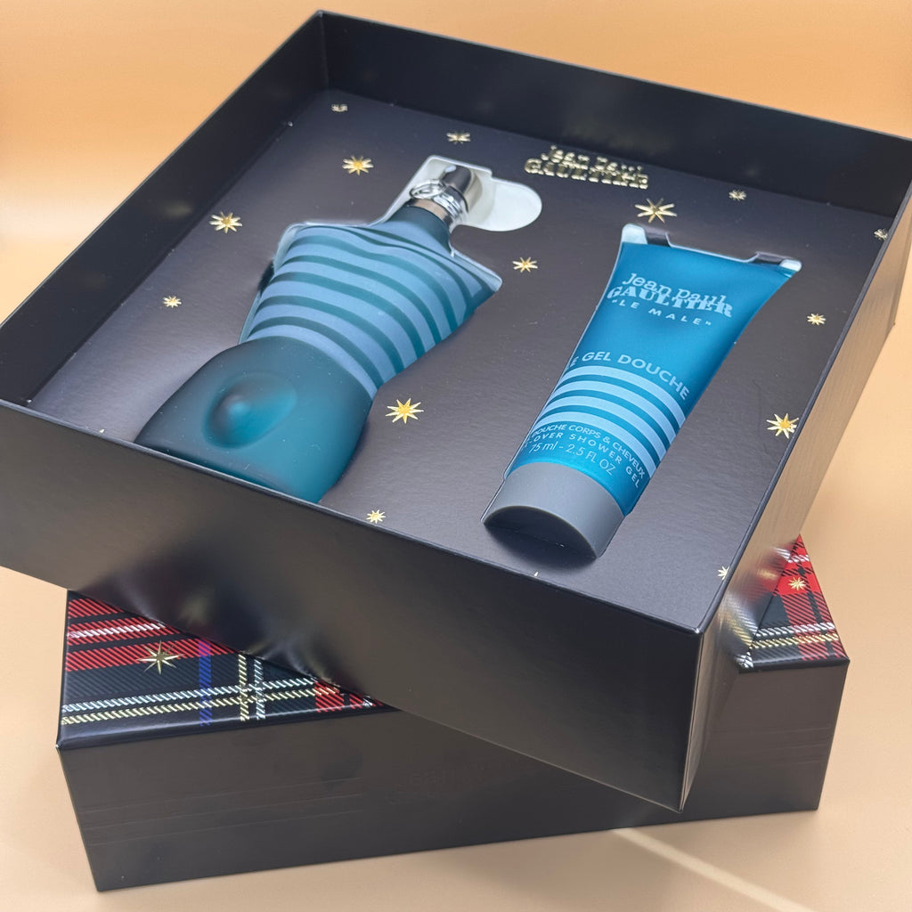 Blue men's grooming set with bottle and tube in a decorative box on a beige background